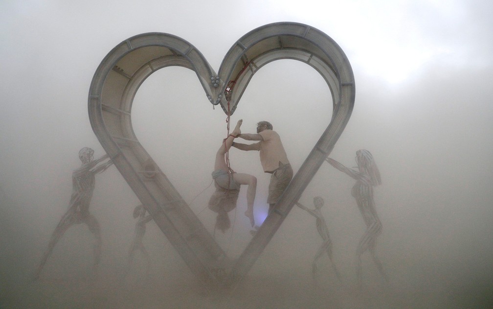 Participantes do festival de arte e música Burning Man realizam uma performance durante uma tempestade de areia no deserto de Black Rock (Foto: Jim Bourg/Reuters)