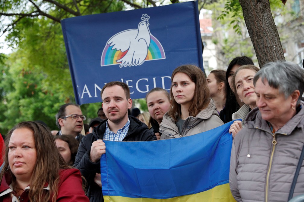 Ucranianos seguram bandeira do pa&iacute;s na Igreja de Santa Isabel da Hungria enquanto esperam a passagem do Papa Francisco pelo local. &mdash; Foto: REUTERS/Bernadett Szabo