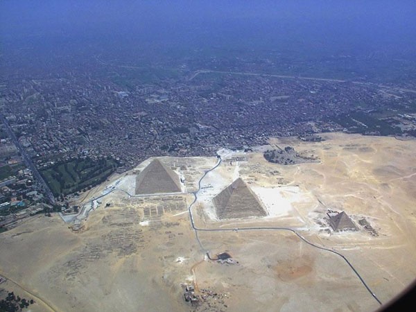 Aqueles que conhecem as pirâmides somente por fotografias e imaginam que elas descansam na solidão do deserto estão enganados; ao sul dos monumentos, é possível ver parte da área suburbana do Cairo (Foto: Reprodução)