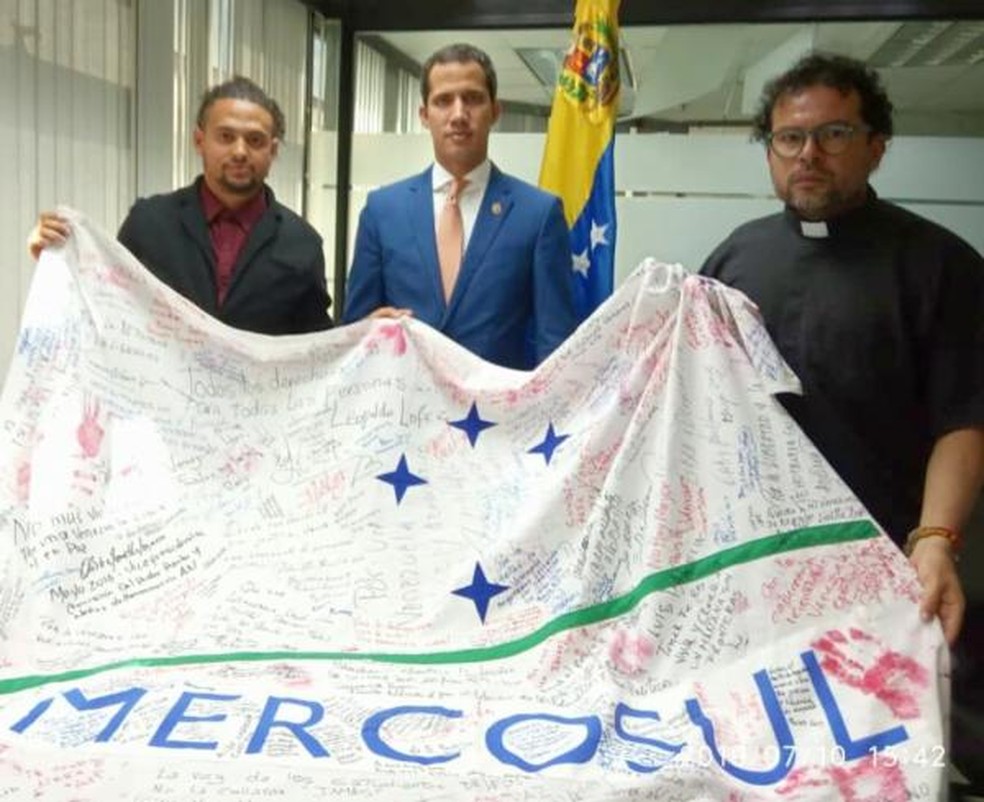 Dado Galvão e Guaidó com a bandeira do Mercosul  — Foto: Elianah Jorge/RFI