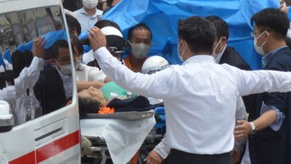 O ex-primeiro-ministro japonês Shinzo Abe é transportado para uma ambulância perto da Estação Yamato Saidaiji após ser baleado na cidade de Nara — Foto: AFP