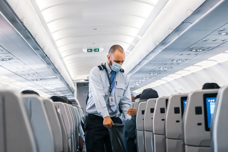 Comissário de bordo de máscara em avião