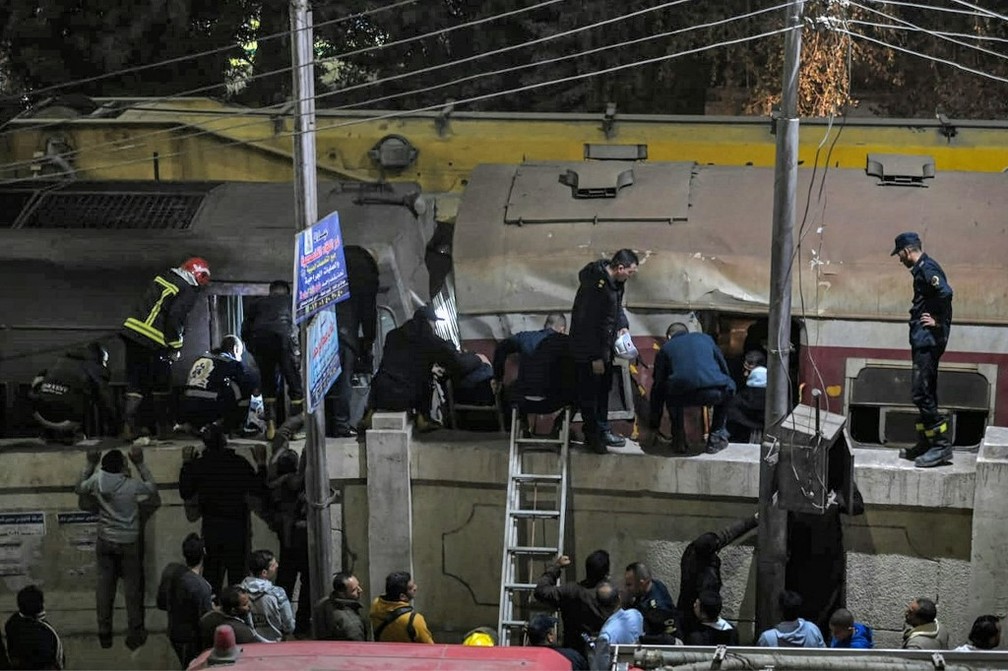 Policiais e socorristas chegam ao local de um acidente de trem na cidade de Qalyub, na província de Qalyub, na região do delta do Nilo, no Egito, ao norte da capital, em 7 de março de 2023. — Foto: Khaled DESOUKI / AFP