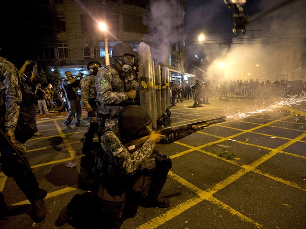Policial dispara contra manifestantes no Rio de Janeiro (Foto: Silvia Izquierdo/AP)