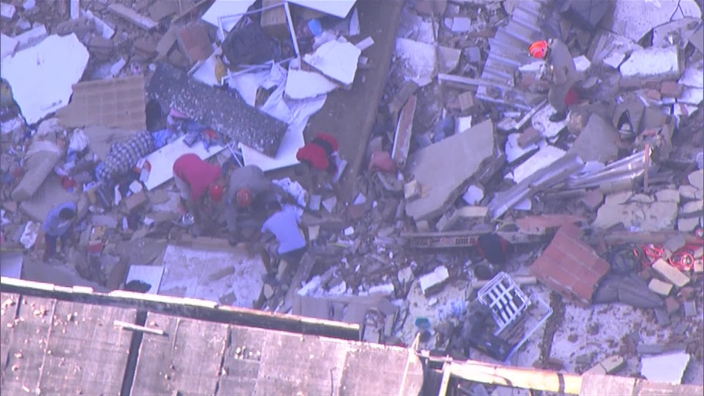 Bombeiros vasculham escombros de prédios que desabaram na comunidade da Muzema — Foto: Reprodução/ TV Globo