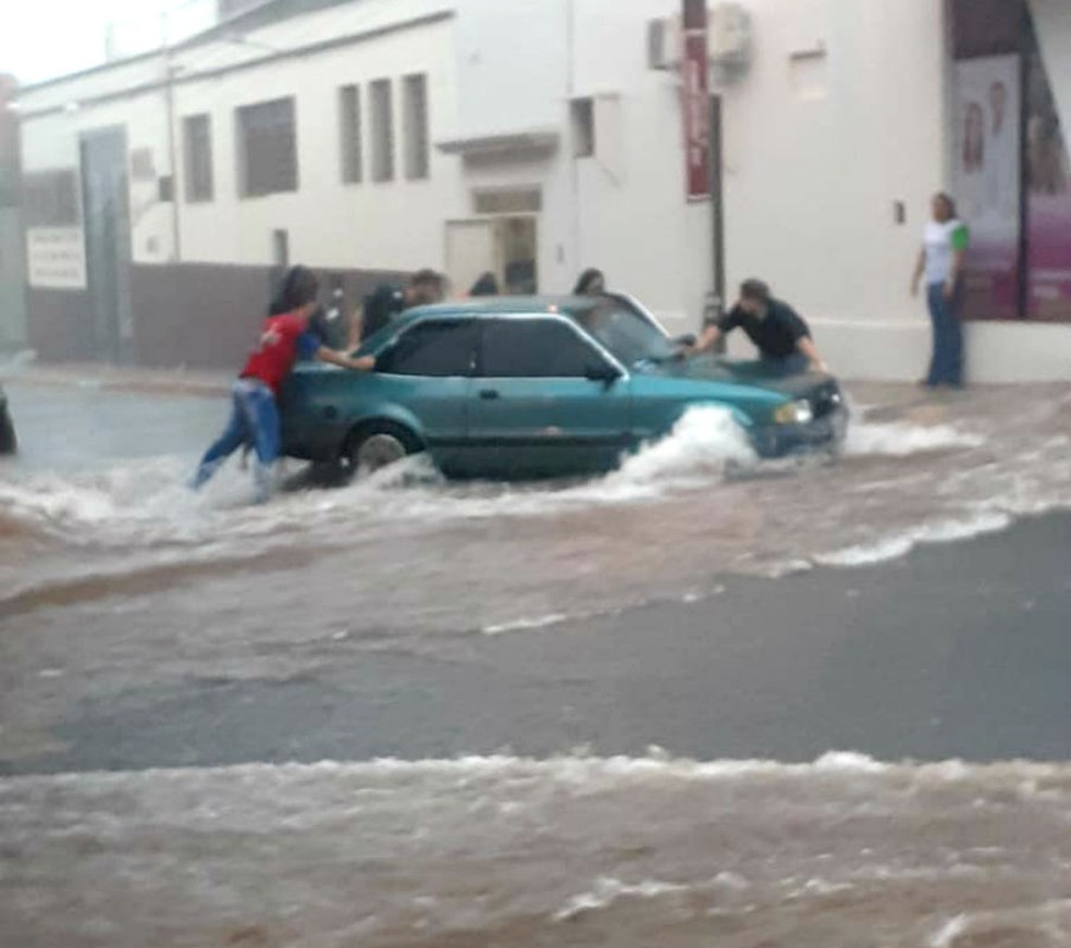 Moradores se juntaram para segurar carro em enxurrada na região da rua Caingangues, em Tupã — Foto: TupãCity/Divulgação