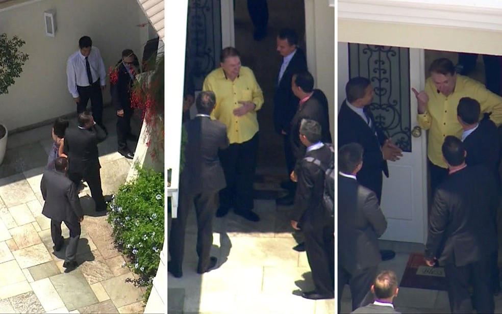 Jair Bolsonaro chega à casa de Silvio Santos (à esquerda); empresário sai à porta e conversa com outras pessoas da comitiva — Foto: José Afonso/TV Globo