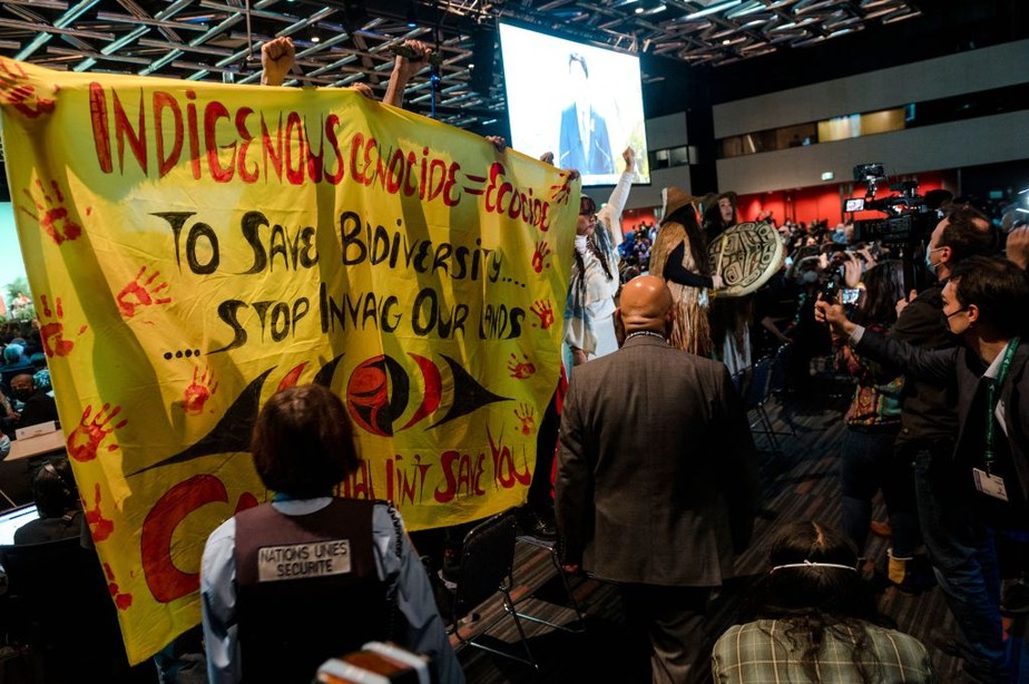Protesto com cartaz na COP15: 'Para salvar a biodiversidade, parem de invadir nossas terras'
