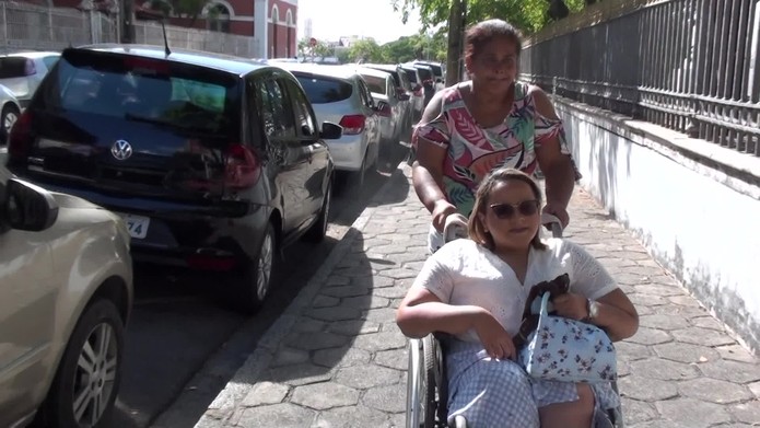 Pâmela precisa de uma cadeira de rodas e de um acompanhante para se locomover pelas ruas do Recife — Foto: Reprodução/TV Globo