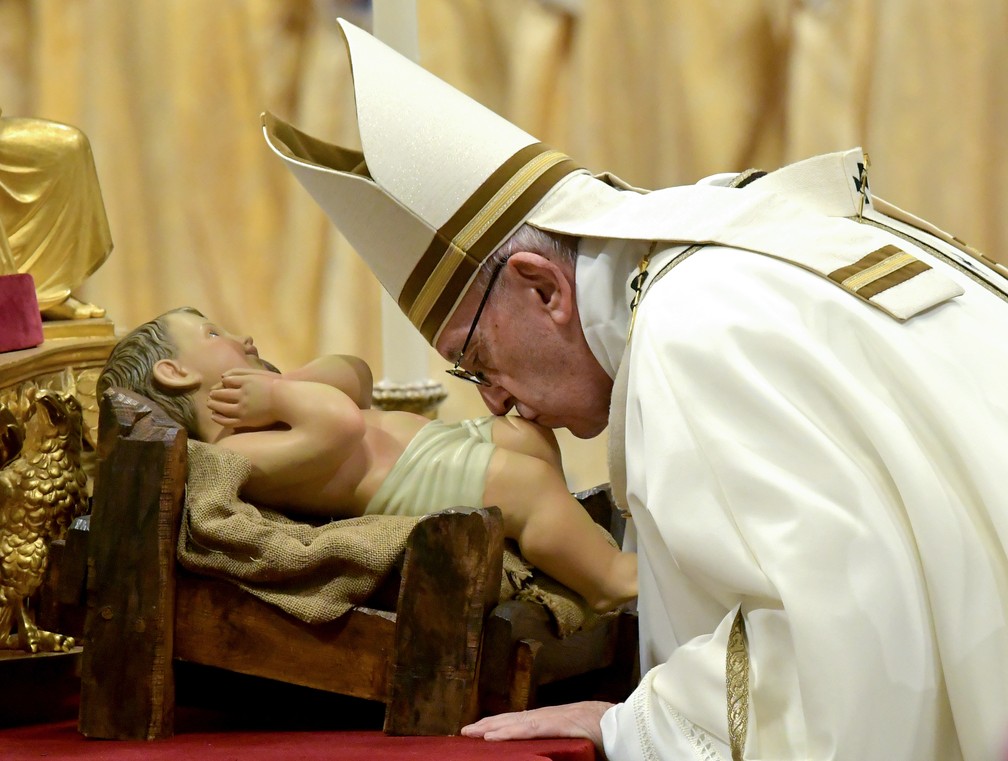 Papa Francisco beja a imagem do menino Jesus durante a Missa do Galo — Foto: Tiziana Fabi/AFP
