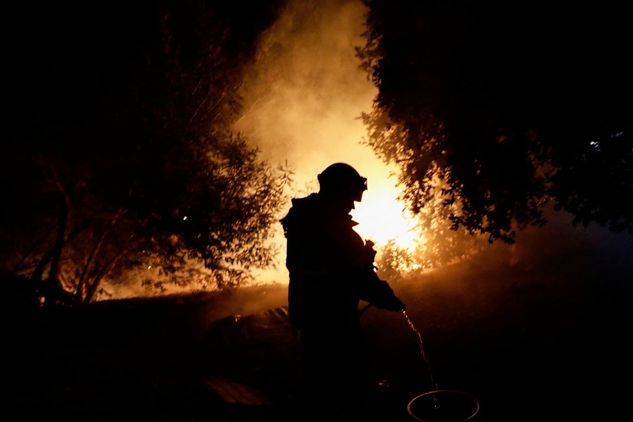 Bombeiro combate incêndio florestal no Chile