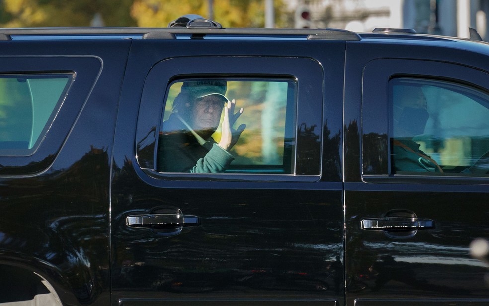Donald Trump, presidente dos EUA, acena para apoiadores ao voltar à Casa Branca neste domingo (8). Ele havia saído para jogar golfe — Foto: J. Scott Applewhite/AP Photo