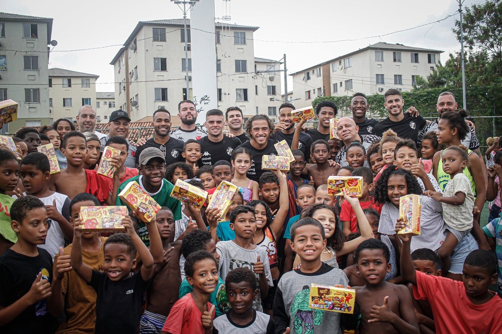 Jogadores do Vasco distribuem chocolates na Cidade de Deus — Foto: Matheus Lima / CRVG