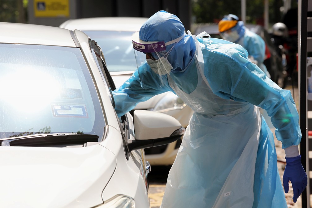 Profissionais de saúde fazem testes em drive-thru para a Covid-19 neste sábado (28) em Petaling Jaya, Malásia. — Foto: Lim Huey Teng/Reuters