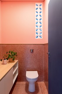 O lavabo exibe piso e meia parede de granilite rosa queimado da GR Pisos. Gabinete desenhado pelo Estúdio Minke, que assina também o projeto, e louças e metais da Deca