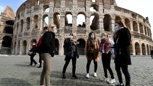 Turistas em Roma usando máscaras; avanço no número de casos do coronavírus provoca propostas xenófobas e disputas políticas na Itália (Foto: EPA via BBC News)