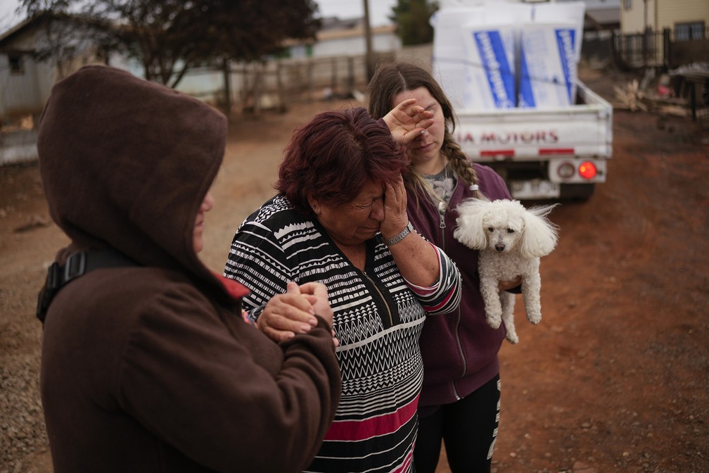 Mulher chora diante de sua casa destruída pelo fogo em Tomé, no Chile — Foto: Matias Delacroix/AP