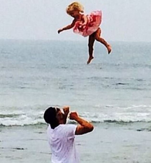 O marido da atriz e cantora Jessica Simpson, o ex-jogador de futebol americano Eric Johnson, em uma foto antiga, na qual aparece jogando a filha mais velha do casal para o alto em uma praia (Foto: Instagram)