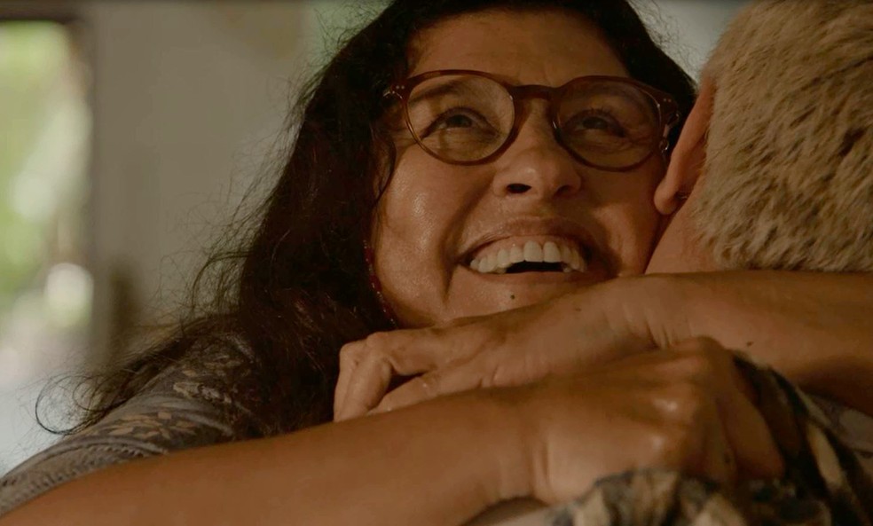 Lurdes (Regina Casé) abraça Ryan (Thiago Martins) ao descobrir pista sobre mulher que comprou o seu filho, em 'Amor de Mãe' — Foto: Globo