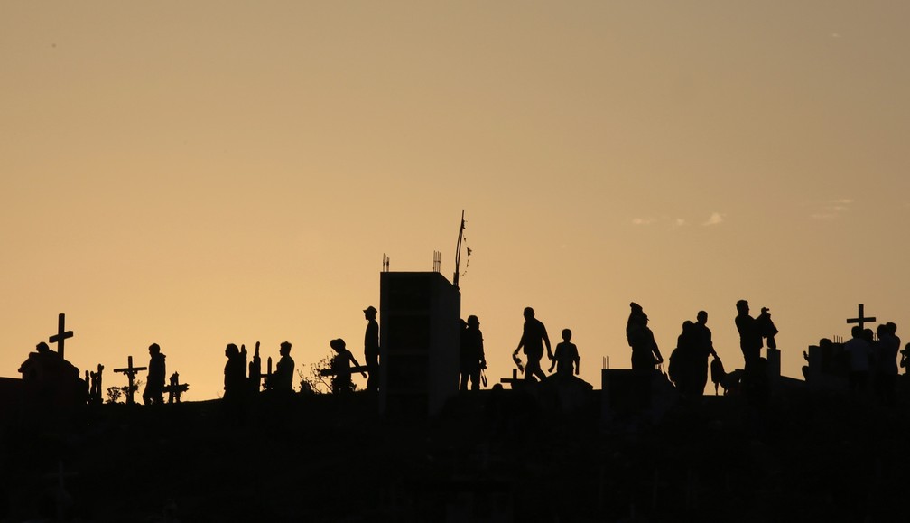 Pessoas caminham durante as celebrações do Dia dos Mortos no cemitério Nueva Esperanza em Lima, no Peru, nesta sexta (1º) — Foto: Martin Mejia/AP