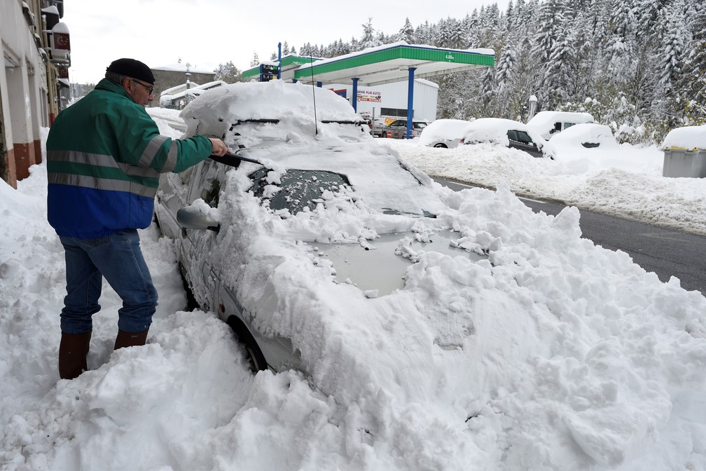 Homem remove neve do seu carro nesta terÃ§a-feira (30) em Firminy, no departamento francÃªs de Loire  â Foto: Jean-Philippe Ksiazek / AFP