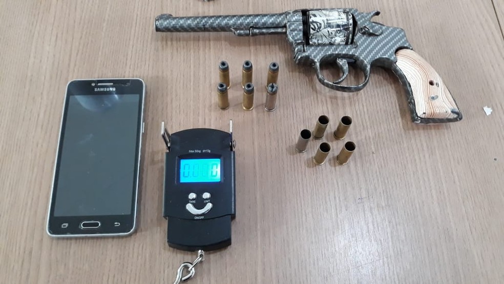 Com os suspeitos também foi encontrada uma arma de fogo  — Foto: Polícia Militar/ Divulgação 
