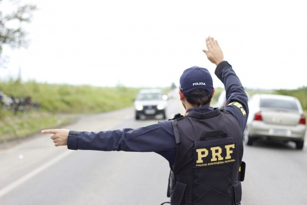 Agente da Polícia Rodoviária sinaliza para motorista durante abordagem — Foto: PRF/Divulgação