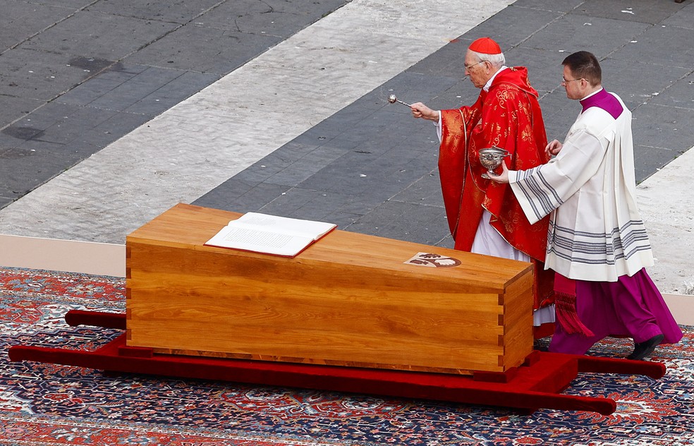 Cardeal Giovani Battista benze o caixão de Bento XVI durante o funeral do papa emérito, em 5 de janeiro de 2023. — Foto: Guglielmo Mangiapane/ Reuters