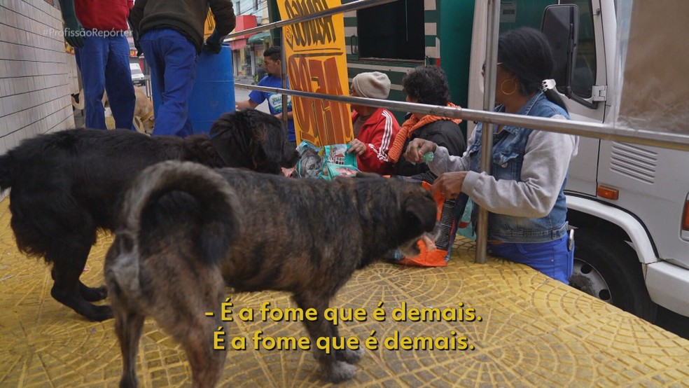 Florinda, os vizinhos e cachorros aguardam restos de açougue — Foto: Profissão Repórter