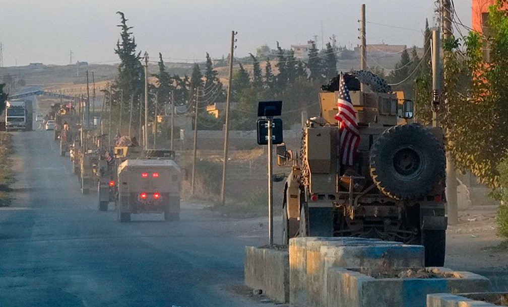 Veículos do Exército dos Estados Unidos passam por estrada no nordeste da Síria, nesta segunda-feira (7)  — Foto: ANHA via AP