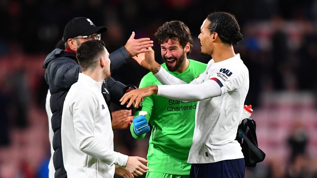 Robertson, Klopp, Alisson e Van Dijk se cumprimentam depois da vitória do Liverpool