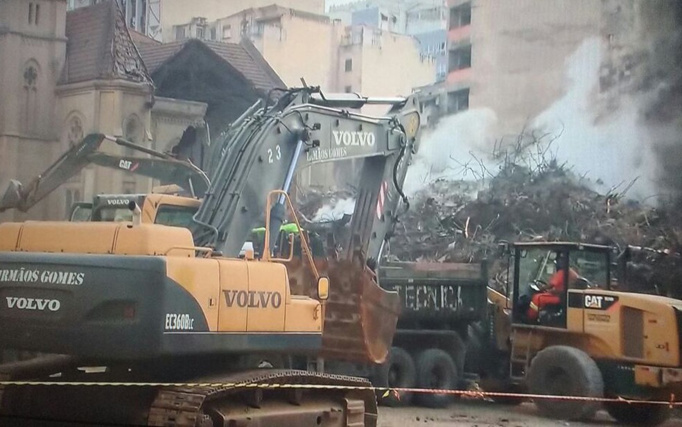 Máquinas e bombeiros trabalham neste sábado nos escombros (Foto: GloboNews/reprodução)