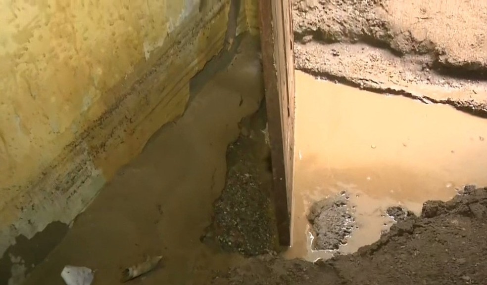 Uma grossa camada de lama se alojou em cima do piso de residência de Campina Grande — Foto: Reprodução/TV Paraíba