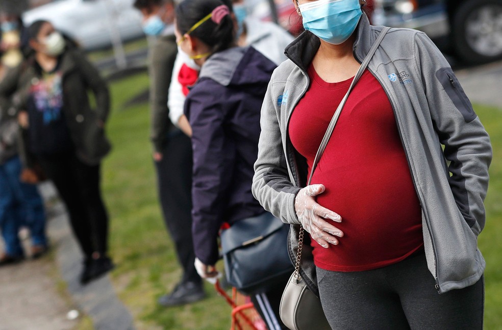 Imagem de arquivo mostra mulher grávida com máscara e luva em Waltham, Massachusetts, nos EUA  — Foto: Charles Krupa/AP 