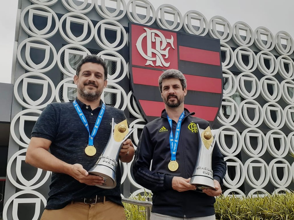 Vice e gerente da base, Zanelli e Freeland posam com as taças de campeão brasileiro sub-17 e sub-20 de 2019 — Foto: Thiago Lima