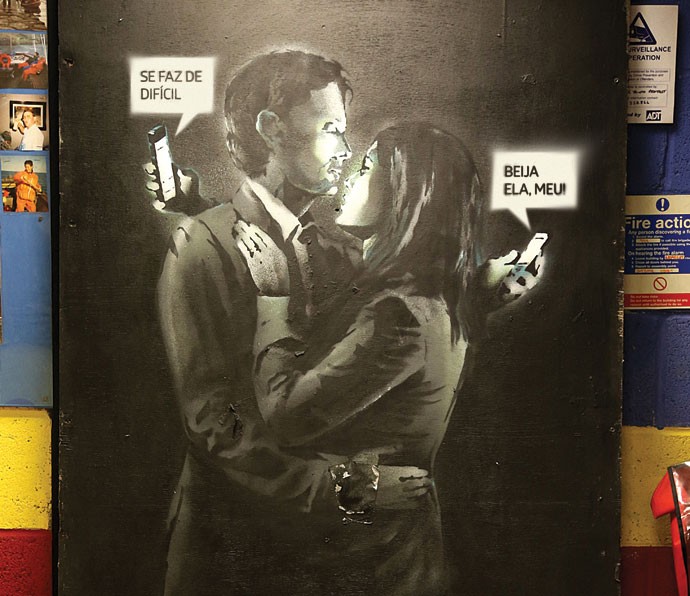 Você recebeu uma nova mensagem:   Em abril, o famoso artista de rua Banksy retratou um casal distraído pelo celular em um dos seus grafites (Foto: Getty Images)