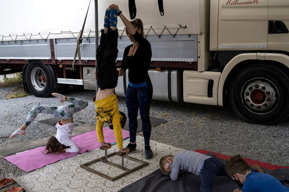 Crianças e uma artista do 'Circo Millennium' se exercitam em Savona, região da Ligúria, no noroeste da Itália, durante o isolamento para combater o novo coronavírus — Foto: Marco Bertorello/AFP
