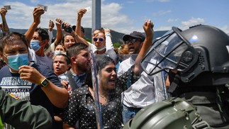 Membros do Esquadrão Móvel Anti-perturbação bloqueiam colombianos que tentam atravessar da Venezuela para votar durante o primeiro turno da eleição na fronteira da Ponte Internacional Simón Bolívar, em Cucuta.  — Foto: Federico PARRA / AFP