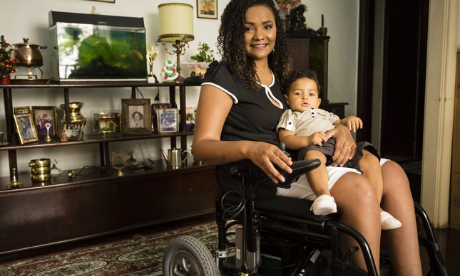 Ana Carolina Rufino, que é cadeirante, com seu filho de 11 meses, João Manoel