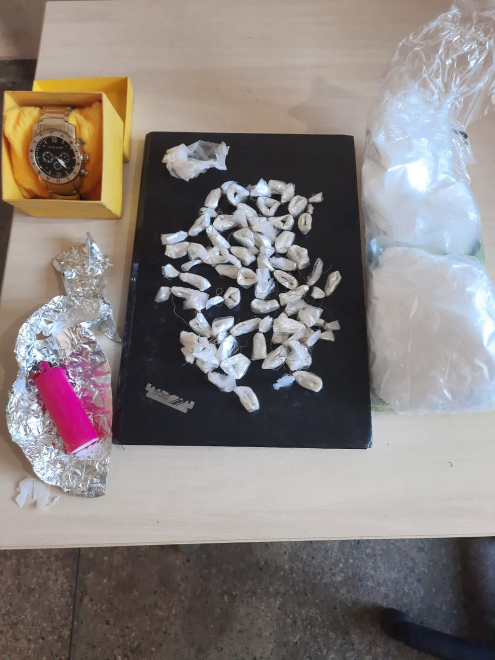 Papelotes de drogas e outros materiais apreendidos com suspeitos foram apresentados na delegacia — Foto: Polícia Militar/Divulgação