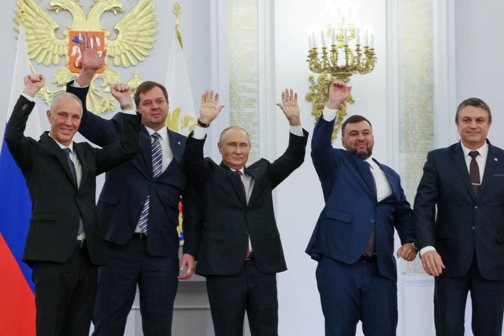 Ao centro, o presidente da Rússia, Vladimir Putin, acompanhado dos interventores russos nos territórios da Ucrânia Denis Pushilin (Donetsk), Leonid Pasechnik (Luhansk), Vladimir Saldo (Kherson) e Yevgeny Balitsky (Zaporizhzhia), durante o anúncio de anexação das regiões, no dia 30 de setembro de 2022 — Foto: Mikhail Metzel/Sputnik/Reuters