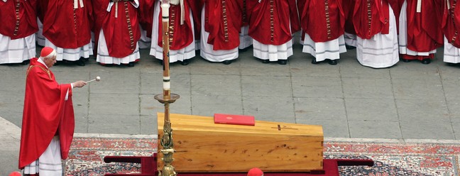 O então cardeal alemão Joseph Ratzinger, que depois se tornaria o papa emérito Bento XVI, abençoa o caixão do papa João Paulo II na Praça de São Pedro, no Vaticano, em 8 de abril de 2005 — Foto: Patrick Hertzog / AFP