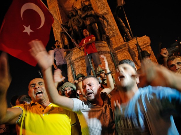 Apoiadores do presidente Recep Tayyip Erdogan protestam na frente de soldados na praça Taksim em Istambul, na Turquia (Foto: Emrah Gurel/AP)