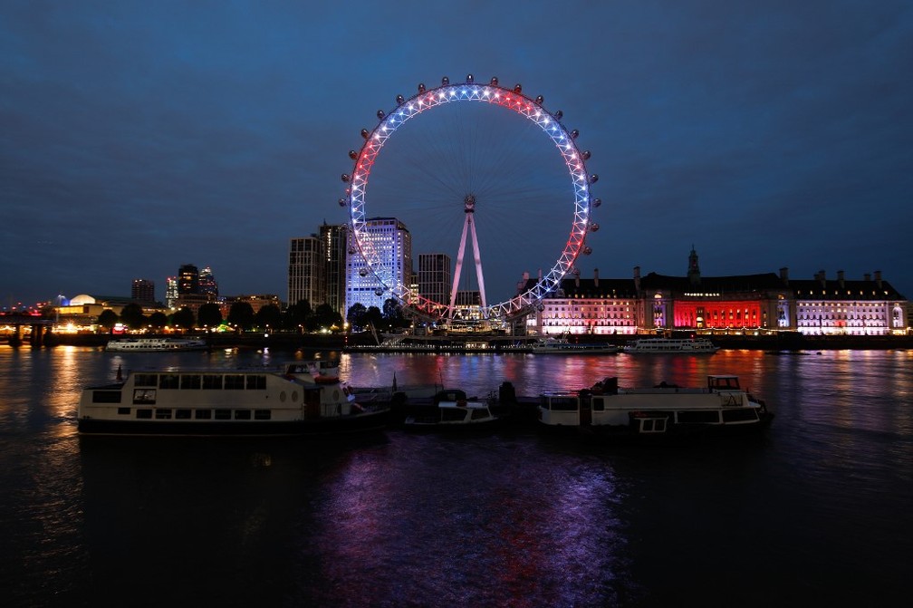 O London Eye aceso em vermelho, branco e azul nesta segunda-feira (6), em homenagem ao nascimento do bebê de Harry e Meghan. — Foto: Tolga Akmen / AFP