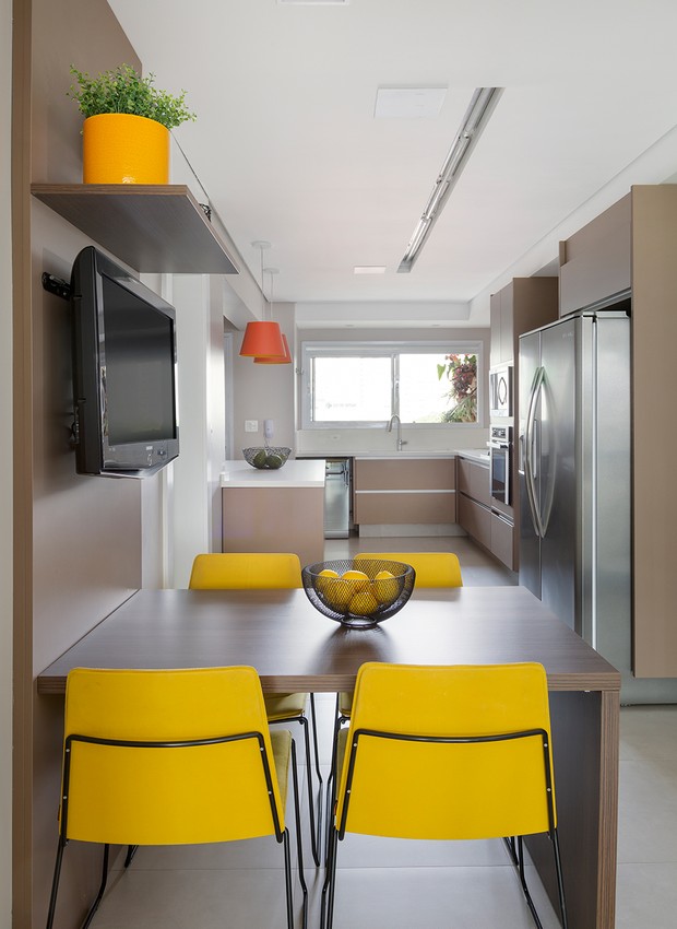 SALA DE ALMOÇO | Integrada à cozinha, uma pequena sala de almoço tem base neutra e pontos de cor a partir das cadeiras amarelas (Foto: Julia Ribeiro/ Divulgação)