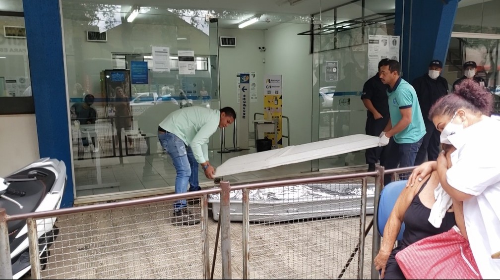 Esposa e enfermeira se abraçam após idoso morrer na porta do INSS em Governador Valadares — Foto: Lorena Cabral/Inter TV dos Vales