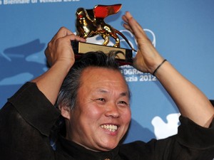 8 de setembro - Kim Ki-duk, da Coreia do Sul, sorri com o Leão de Ouro na cabeça após vencê-lo no Festival de Veneza por filme 'Pieta' (Foto: Tiziana Fabi/AFP)