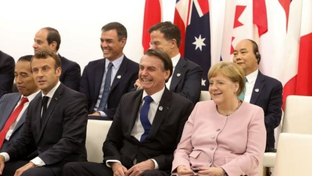 Bolsonaro (centro) com Emmanuel Macron (esq.) e Angela Merkel (dir) no Japão: presidente perderia a aposta a respeito da Amazônia (Foto: PRESIDÊNCIA DA REPÚBLICA VIA BBC)