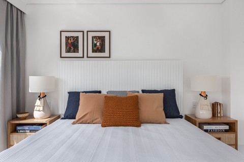 Quarto confortável tem cama ampla, base 'clean' e toques étnicos, com texturas e cores. Projeto do escritório Studio 3.7