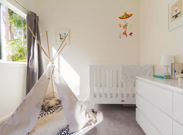 Os tons de branco e a cabana de brinquedo são destaques nesse quarto de bebê em Sydney, Austrália (Foto: Reprodução / Airbnb)